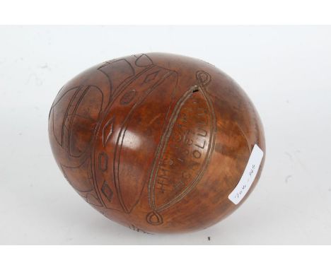 19th Century scrimshaw coconut, the body engraved with a profile portrait, pair of shaking hands, cherub and a crown above in