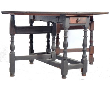 An 18th Century George II oak double gate leg / gateleg drop leaf dining table having twin functioning drawers, one to each e