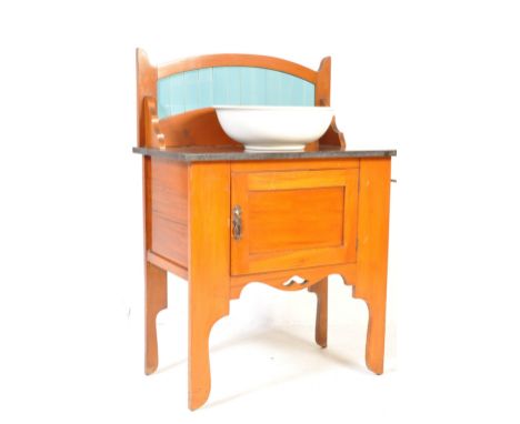 An Edwardian satin walnut vintage washstand cabinet having wooden teal enamel tiles to the back, slate top and single door cu