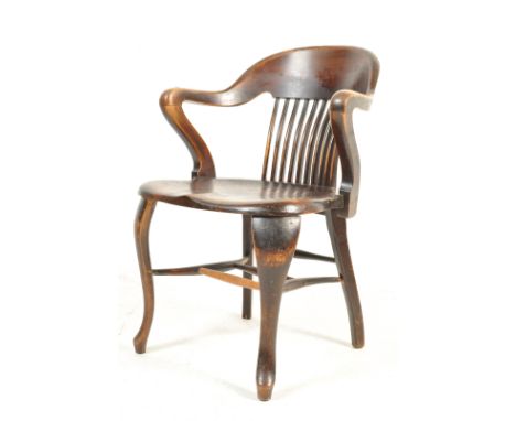 An early 20th century Edwardian circa 1910 mahogany office chair having a shaped back with a comb backrest over a saddle seat