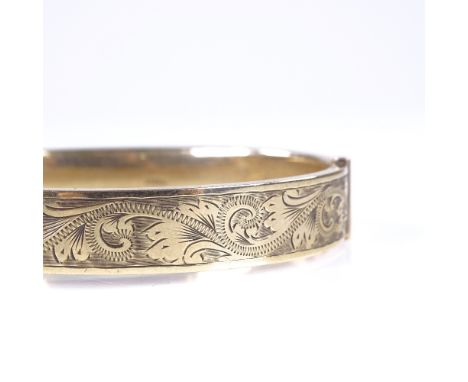 A mid-20th century 9ct gold hinged bangle, engraved foliate decoration, hallmarks Birmingham 1961, band width 10mm, internal 