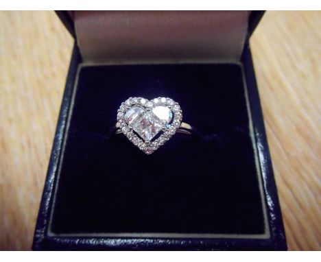 An 18ct white gold ring with three diamonds to centre forming a heart, surrounded by twenty two small diamonds in cluster set