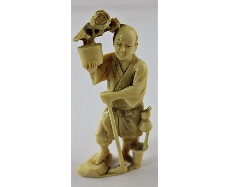 A Japanese Meiji period carved ivory okimono, of a man with walking stick carrying a pot of flowers, height 11.2cm.