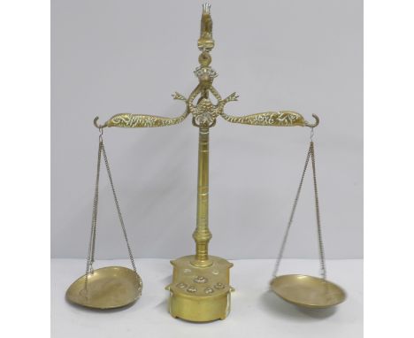A set of brass balance scales and weights, two weights missing 