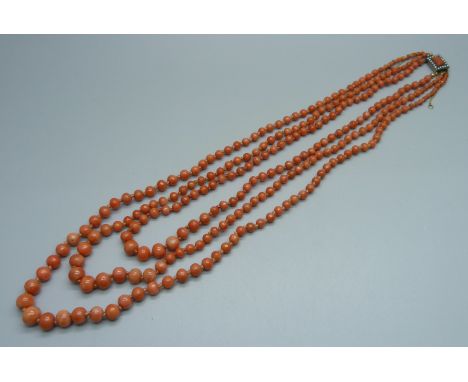 A vintage three strand coral necklace with pearl set yellow metal clasp, 62.4g 