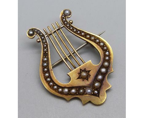 A Victorian 15ct gold harp brooch set with seed pearls, Birmingham 1885, 6.5g, 28mm wide, lacking one pearl 