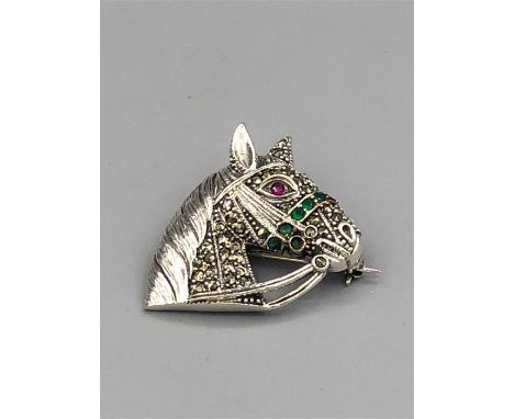 A silver and Marcasite brooch in the form of a Horse Head inset with emeralds and ruby eye