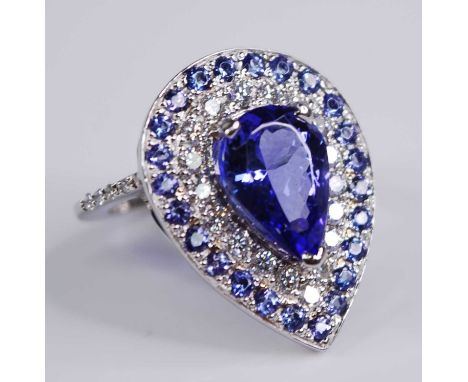 A white metal, tanzanite and diamond pear shaped cluster ring, featuring a centre pear cut tanzanite within a border of 18 ro