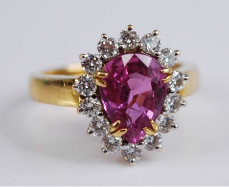 A yellow and white metal, tourmaline and diamond pear shaped cluster ring, featuring a pear cut pink tourmaline within a bord