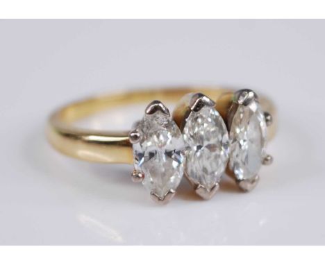 A yellow metal diamond three stone ring, the claw set marquise cut diamonds in a line setting, each weighing approx 0.45 cara