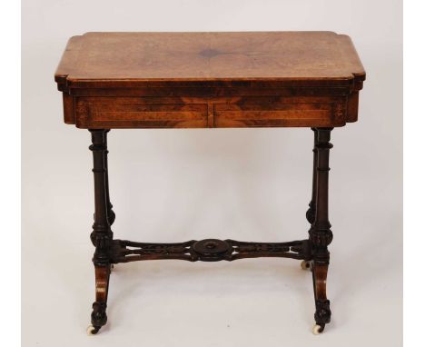 A mid-Victorian figured walnut and birds-eye maple inlaid foldover card table, having a baize lined playing surface, swivel a