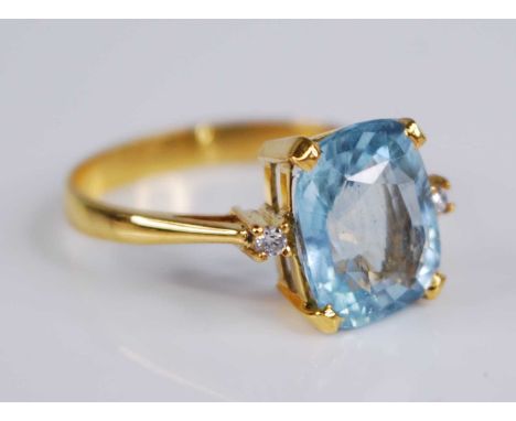 A yellow metal aquamarine set dress ring, the four-claw set oval cut aquamarine measuring approx 11 x 9 x 5mm, within diamond