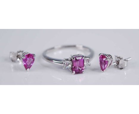 An 18ct white gold, pink sapphire and diamond three stone ring, the four-claw set emerald cut pink sapphire weighing approx 0