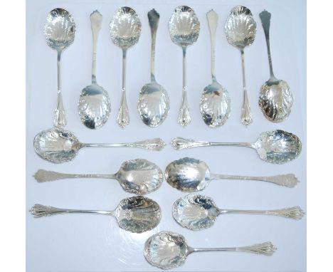 A matched set of fifteen early 20th century silver caddy spoons, the shaped scroll-edged bowls repousse cast with feathers an