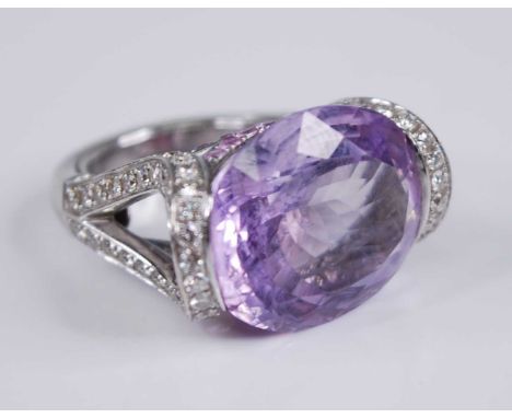 A contemporary French 18ct white gold, amethyst and diamond dress ring, arranged as a large oval cut amethyst measuring appro