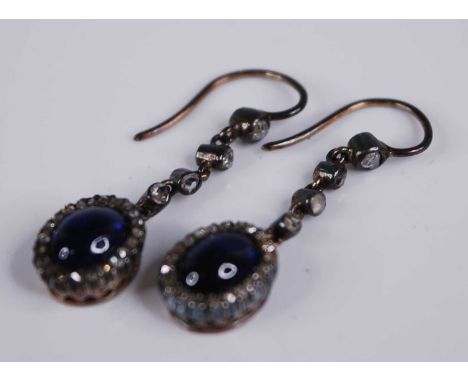 A pair of early 20th century sapphire and diamond set ear pendants, the blue sapphire cabochons each measuring approx 7.5 x 6