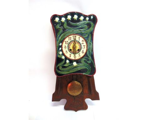 A CONTINENTAL OAK AND CERAMIC WALL CLOCK,  the majolica face and surround with stylised floral decoration, the oak case carve