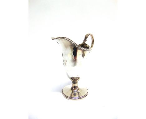 A GEORGE III SILVER CREAM JUG by Robert Hennell, London 1782, of helmet shape on a short pedestal foot with beaded borders, l