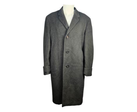 A black three quarter length buttoned overcoat made with cloth from Crombie of Aberdeen for the mens clothing shop Dunn &amp;