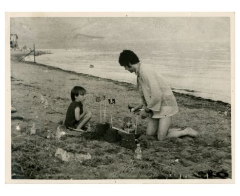An original vintage sixties press photograph showing Paul McCartney building sand castles on the beach at Itea, Greece with J