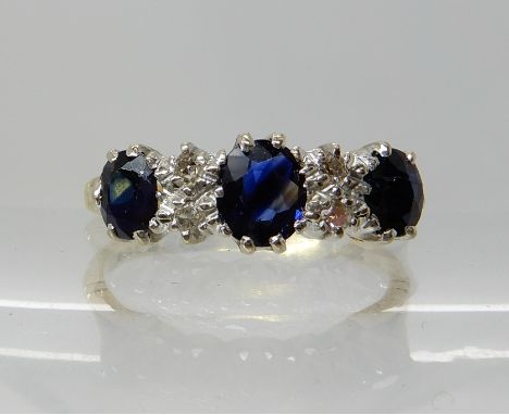 An 18ct gold sapphire and diamond linear cluster ring, zoning visible in the sapphires largest approx 5.3mm x 4.4mm x 2mm, fi