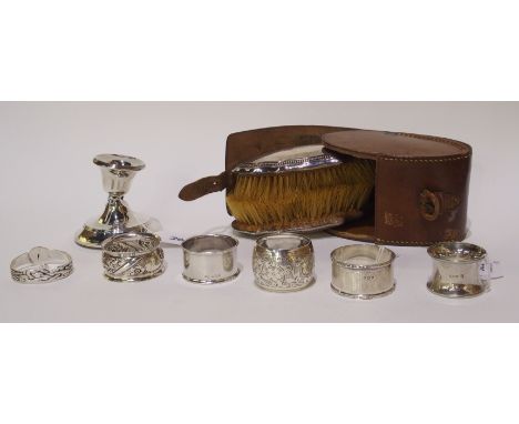 Six various silver napkin rings, a leather cased silver brush set and a silver candlestick (def) Condition Report: Available 