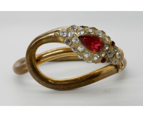 A gold plated gem set snake bangle, one clear gem missing Condition Report: Available upon request