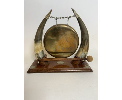 A Large brass gong with horn supports and silver plated mounts on original oak base with gong stick.