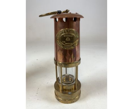 A Copper and brass miners lamp with printed leaflet and original packaging tube. H:26cm