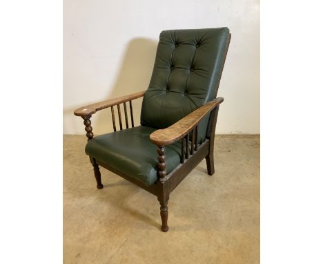 An early 20th century leather reclining oak armchair with bobbin and stick supports. W:70cm x D:70cm x H:90cm