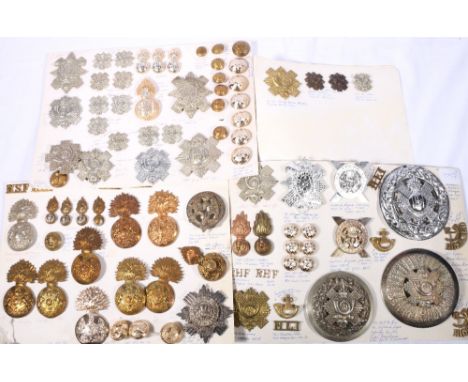 Four prepared boards of cap badges, buttons, shoulder titles and collar badges pertaining to The Highland Light Infantry, Roy