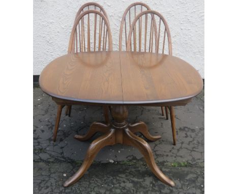 Ercol mid 20th century oak extending dining table, with four stick back chairs to accord. Approx. 73cms H x 149cms W x 90cms 