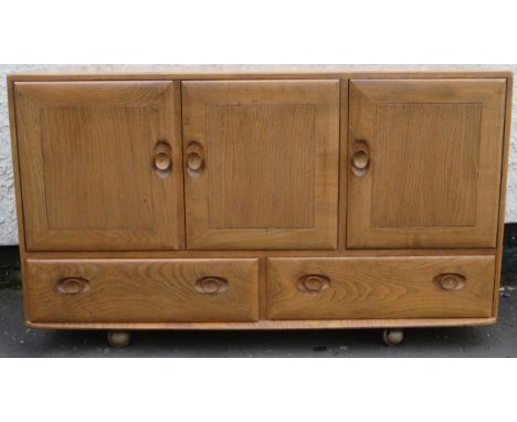 Ercol mid 20th century light oak three door sideboard with two drawers below. Approx. 76cm H x 129cm W x 44cm D 