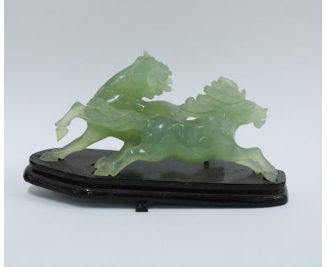 Carved jade figure of a galloping horse, on a wooden stand. 21cm 