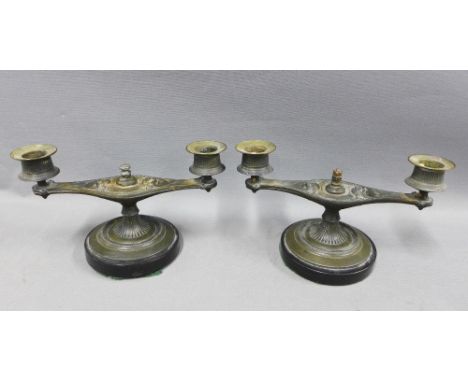 Pair of bronze Aladdin lamp style candelabra, on black circular hardstone bases, 20 x 12cm (2) 