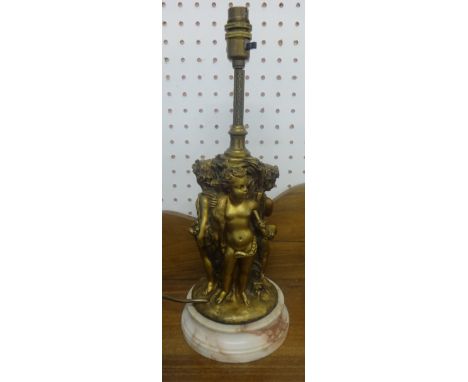 A gilt metal heavy table lamp in the form of three putti on marble socle base, height 38cm