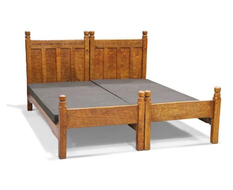 ROBERT THOMPSON OF KILBURN, A PAIR OF EARLY MOUSEMAN OAK SINGLE BEDS, CIRCA 1930S each four-panel headboard carved with a mot