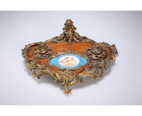 A NAPOLEON III ORMOLU, SÈVRES STYLE PORCELAIN AND KINGWOOD INKSTAND cartouche-shaped, inset porcelain panel depicting two put