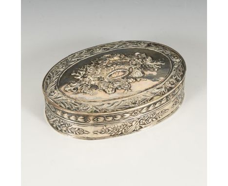Ovale Silberdose mit Blütenreliefs. 800/Krone gepunzt. Anfang 20. Jh.             Silber, innen vergoldet. 3 x 11,5 x 8 cm. 1