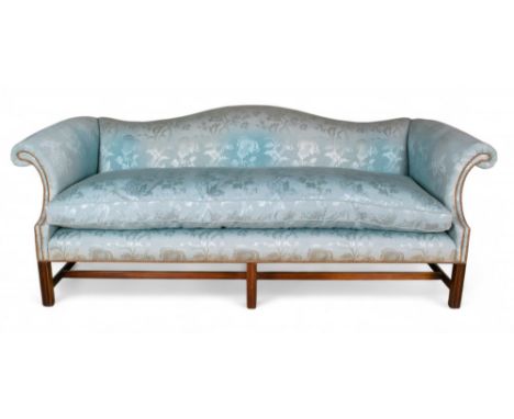 A George III style camelback sofa  Straight backed, upholstered in pale blue silk, with mahogany legs and scroll arms.  Forme