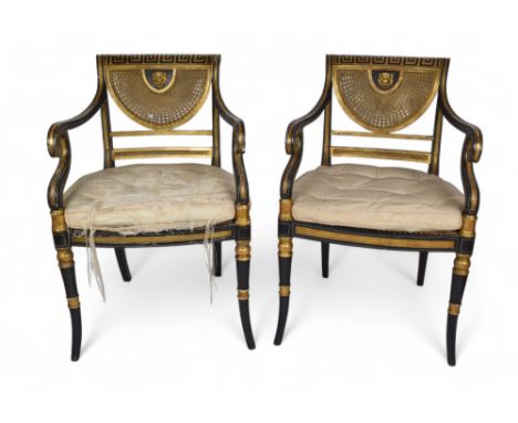 English Regency A pair of japanned canework elbow chairs The gilded backs decorated with painted meander motif, above lion ma