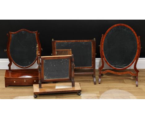 A George III Revival mahogany shield-shaped dressing mirror, the bowed base with a long drawer, bracket feet, 52.5cm high, 38