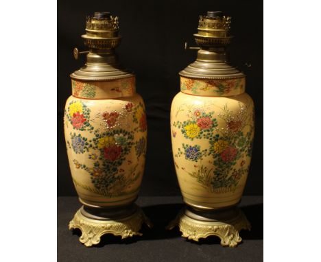 A pair of French oil lamps, the ceramic body decorated in the Japanese taste, later converted to electricity, 41cm high over 