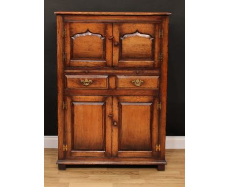 An oak side cabinet, possibly Titchmarsh &amp; Goodwin, rectangular top above a pair of pointed-arch raised and fielded panel