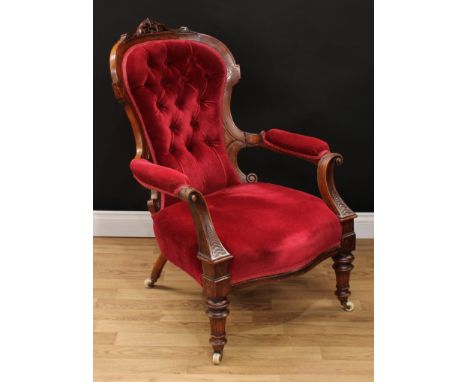 A Victorian walnut drawing room open armchair, curved cresting carved and applied with Greek key acanthus, deep button back, 