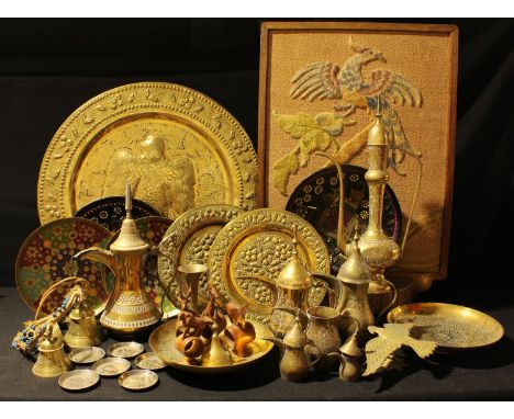 An Indian brass charger; other Indian and Middle Eastern metal ware; a ewer; bells; etc; an early 20th century oak and needle
