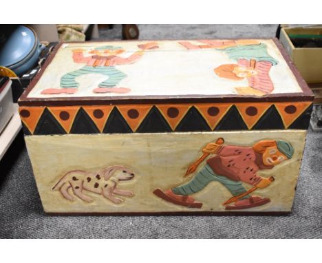 A vintage children's toy chest or trunk, having carved case with pendant border and painted clown design 77cm long, 45cm wide