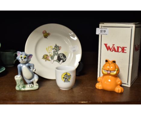 A selection of cartoon items including Garfield and Tom cat Wade figures with a Tom and Jerry egg cup and plate