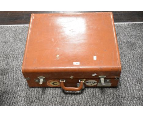 A vintage leather bound suitcase trunk with Aznar line and Wings badges.