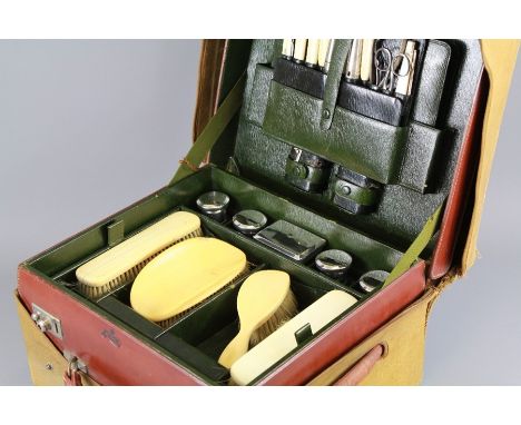 A Gentleman's Travelling Grooming Case. The case of robust leather construction with a fitted interior of ivory, silver and c